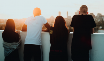 Four teenagers looking at a city landscape.